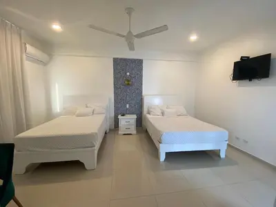a bedroom with two beds and a ceiling fan at Hotel Down Town Cabrera in Cabrera