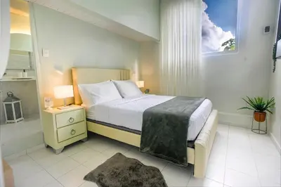 a bedroom with a bed and a window and a nightstand at Estudio 2 Conde 504 at Historic Main Street in Santo Domingo