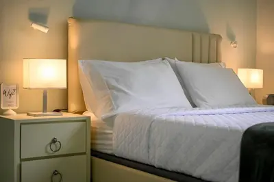 a bedroom with a bed with white sheets and two lamps at Estudio 2 Conde 504 at Historic Main Street in Santo Domingo