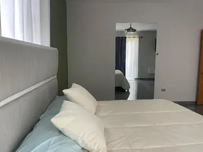 a bedroom with a bed with white sheets and pillows at Casa Finca El Encanto - 8 pax, A Minutos de la Playa in Arroyo El Cabo