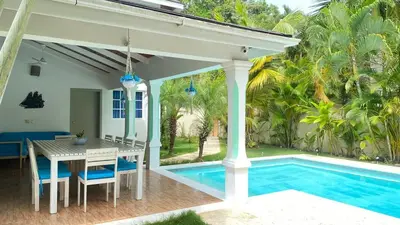 a patio with a table and a swimming pool at Villa Langosta in Las Terrenas