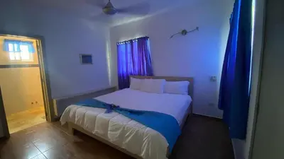 a bedroom with a large bed with blue curtains at Villa Langosta in Las Terrenas