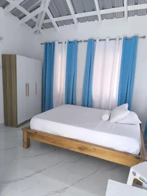 a bedroom with a bed with blue and white curtains at Room Vanesa in Las Terrenas