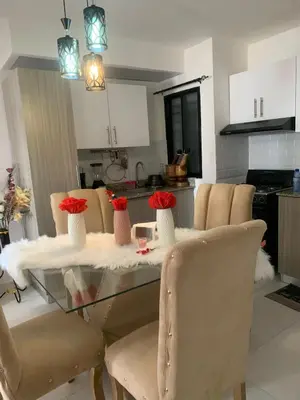 a dining room table with red roses in vases on it at Residencial habitat uno in Los Paredones