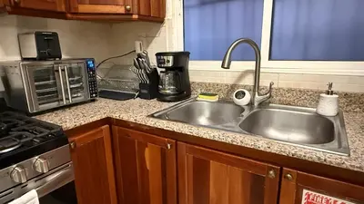 a kitchen counter with a sink and a microwave at Cozy and Beautiful, 3 Bedroom Apartment Home in Santo Domingo