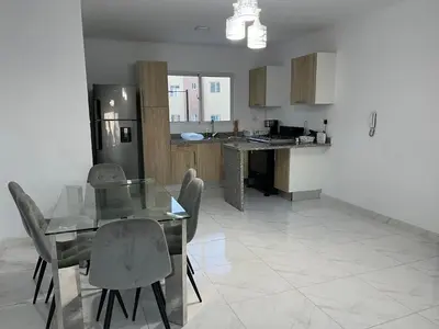 a kitchen with a glass table and chairs in it at Ocean View Apartment in Santo Domingo Este in La Viva