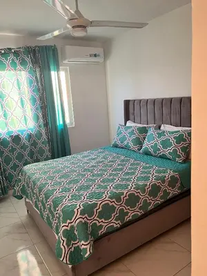 a bedroom with a bed with a green comforter at Ocean View Apartment in Santo Domingo Este in La Viva