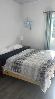a bedroom with a bed with a fan and a window at Bargain Beach Getaway in Las Terrenas