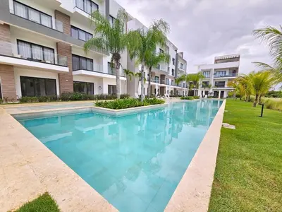 a swimming pool in front of a building at Cana Cove in Punta Cana