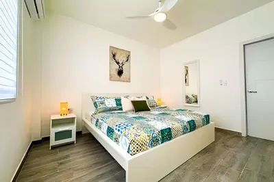 a white bedroom with a bed and a window at Condominio privado con piscina, cerca de la playa in Punta Cana