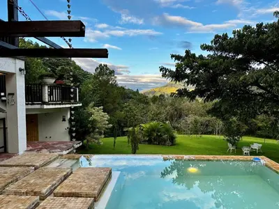 a swimming pool with a view of a yard at Villa del Pino en Quintas del Bosque in Jarabacoa
