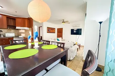 a dining room and living room with a dining table at Condominio con piscina, cerca de la playa in Punta Cana
