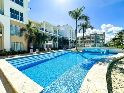 a swimming pool in front of a building at Cana Pearl Fase I y II in Punta Cana