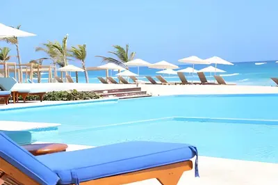 a swimming pool with chairs and umbrellas at a resort at Cana Pearl Fase I y II in Punta Cana