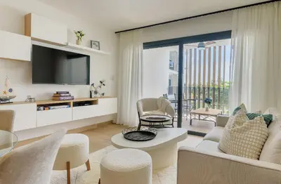a living room with a couch and a tv at Escapada caribena: Piscina y cerca de la playa in Punta Cana