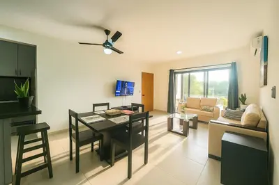 a living room with a table and a dining room at Modern Serviced Apartment with Free Wi-Fi, 24h Power & Private Parking in Sosúa