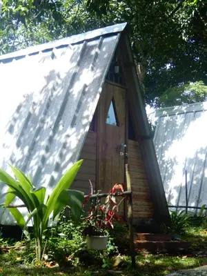 a small wooden house with a pitched roof at Eco Camping Jarabacoa in Jarabacoa