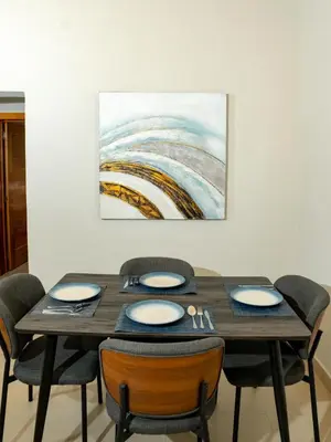 a dining room table with chairs and a painting on the wall at Ocean Winds Hotel in San Felipe de Puerto Plata