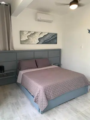 a bedroom with a bed with a purple comforter at Villa Tula in Sosúa