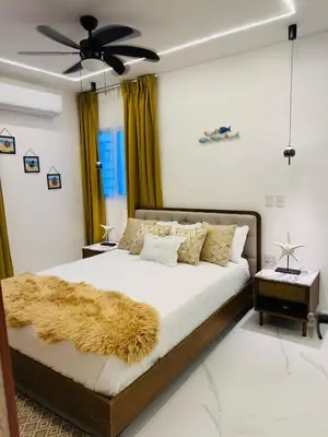 a bedroom with a large bed with a brown blanket at Residencial mar azul Bayahibe in Bayahibe