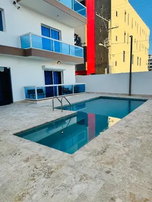 a swimming pool in front of a building at Residencial mar azul Bayahibe in Bayahibe