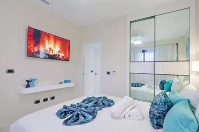 a white bedroom with a bed with a fireplace at Comfy Retreat Balcony Grill Pool in Punta Cana