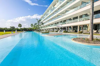 a large swimming pool in front of a building at Comfy Retreat Balcony Grill Pool in Punta Cana