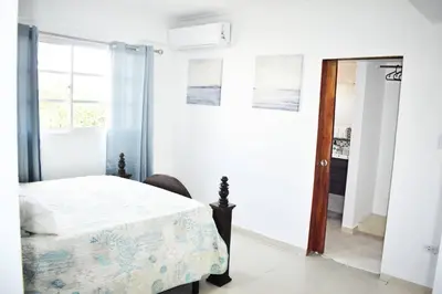 a white bedroom with a bed and a mirror at Best location Big 3 Bdrs, Fully Stocked and A/C in Santo Domingo