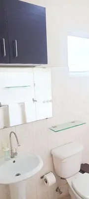 a bathroom with a white toilet and a sink at Apartamento en Residencial Los Pinos Cotui in Cotuí