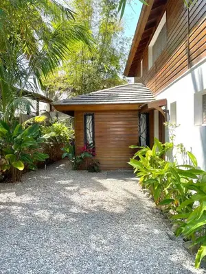 a house with a wooden garage next to a building at Tropical Bliss Retreat in Las Terrenas
