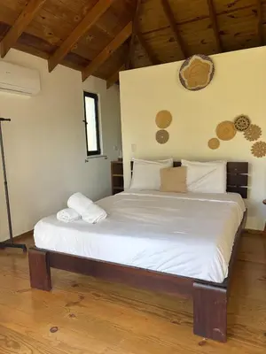 a bedroom with a large bed with white sheets at Tropical Bliss Retreat in Las Terrenas