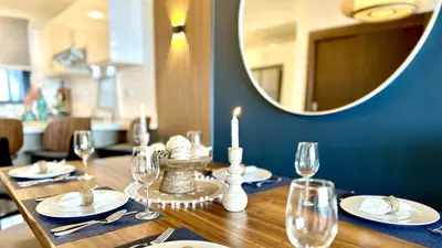 a dining room table with a candle and a mirror at ALL-NEW Modern and Stylish Apartment with Rooftop Infinity Pool in Las Terrenas