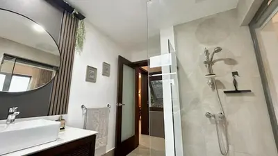 a bathroom with a shower and a sink and a mirror at ALL-NEW Modern and Stylish Apartment with Rooftop Infinity Pool in Las Terrenas