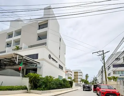 a white building with cars parked in front of it at Gardenia B31 in Punta Cana