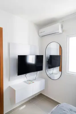 a white room with a tv and a mirror at SoliMar Caribeño in Boca Chica