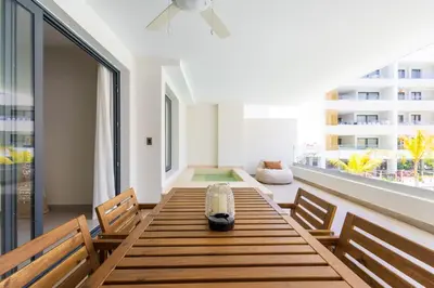 a dining room with a table and chairs and a window at Brand New 2BR Stylish Apartment in the Heart of Punta Cana, Gardenia Gated Community in Punta Cana