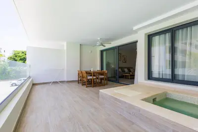 a living room with a hot tub and a table at Brand New 2BR Stylish Apartment in the Heart of Punta Cana, Gardenia Gated Community in Punta Cana