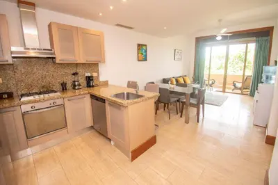 a kitchen and living room with a table and a dining room at Espectacular Apto en Casa de Campo Los Altos 3 in La Romana