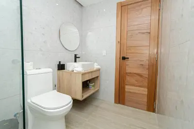 a bathroom with a toilet and a sink and a mirror at Spacious 3BD Penthouse Private Rooftop Sea Breeze - Oasis in San Rafael del Yuma