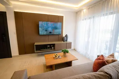 a living room with a couch and a tv at Views, pool and gym, 2 BR family friendly in Santiago de los Caballeros