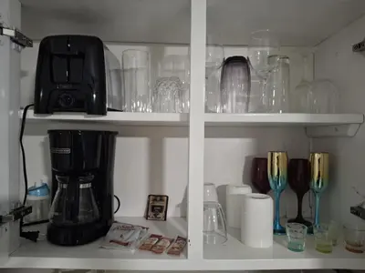 a shelf filled with glasses and a blender at Beautiful condo in Sosua walking distance from everything in Sosúa
