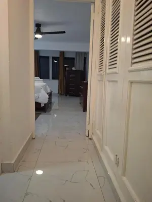 a hallway with a room with a bed and a white floor at Beautiful condo in Sosua walking distance from everything in Sosúa
