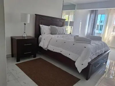 a bedroom with a large bed and a night stand with a lamp at Beautiful condo in Sosua walking distance from everything in Sosúa
