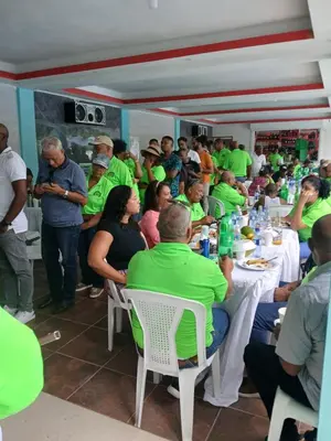 a group of people in green shirts sitting at tables at Paraíso Vacacional FERNANDO in Polo