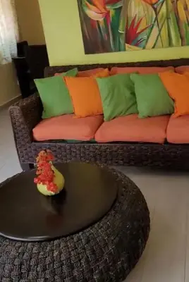 a living room with a couch and a table at Garden condos in Sosúa