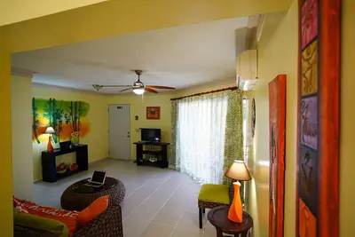 a living room with a couch and a tv at Garden condos in Sosúa