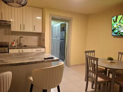 a kitchen with a table and chairs and a counter at Modern condo in middle of Sosua in Sosúa