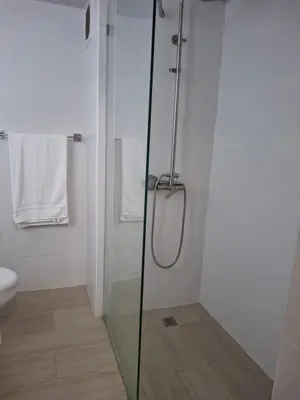 a shower with a glass door in a bathroom at Modern condo in middle of Sosua in Sosúa