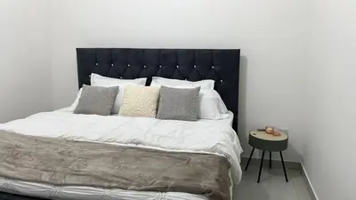 a bedroom with a large bed with white sheets and pillows at Luxury first floor Apartment Pool kingside suite in Santiago de los Caballeros