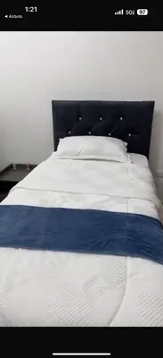 a bed with a blue and white blanket on it at Luxury first floor Apartment Pool kingside suite in Santiago de los Caballeros